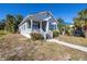 Charming single-story home featuring a cozy front porch, gray siding and mature palm trees in a sunny, landscaped yard at 719 19Th S St, St Petersburg, FL 33712