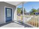 Inviting front porch showcases a stylish blue front door and sleek gray deck overlooking the street at 719 19Th S St, St Petersburg, FL 33712