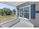 Inviting front porch features gray wood-look flooring and a view of the greenery across the street at 719 19Th S St, St Petersburg, FL 33712