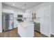 Bright kitchen boasts white cabinetry, stainless steel appliances, and a center island with quartz countertop at 719 19Th S St, St Petersburg, FL 33712