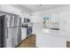 Beautiful kitchen features stainless steel appliances, white cabinets and quartz countertops, and wood floors at 719 19Th S St, St Petersburg, FL 33712