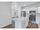 Open-concept kitchen features modern appliances, white cabinets, island, and seamless flow to living area at 719 19Th S St, St Petersburg, FL 33712