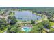 Community pool with lake view and palm trees at 2925 Winding Trail Dr, Valrico, FL 33596