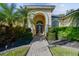 Inviting entryway with a paved walkway, lush landscaping, and arched entry at 2925 Winding Trail Dr, Valrico, FL 33596