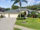 A charming house with a large driveway, lush landscaping, and a three-car garage at 2925 Winding Trail Dr, Valrico, FL 33596