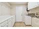 Functional laundry room with white cabinets and shelving at 2925 Winding Trail Dr, Valrico, FL 33596