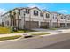 Two-story townhouses with attached garages and landscaping at 31464 Woodland Race Loop, Wesley Chapel, FL 33545