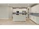 White kitchen with gray countertops, island, and light blue backsplash at 31464 Woodland Race Loop, Wesley Chapel, FL 33545