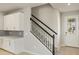 Modern staircase with white cabinets and gray tile at 31464 Woodland Race Loop, Wesley Chapel, FL 33545