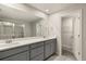 Modern double vanity bathroom with gray cabinets and a walk-in shower at 31471 Woodland Race Loop, Wesley Chapel, FL 33545