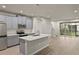 Modern kitchen with gray cabinets, island, stainless steel appliances, and luxury vinyl plank flooring at 31471 Woodland Race Loop, Wesley Chapel, FL 33545