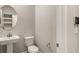 Modern powder room with pedestal sink, toilet and oval mirror at 31471 Woodland Race Loop, Wesley Chapel, FL 33545