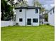 View of a two-story house with a well-kept backyard and white fence at 4204 N 13Th St, Tampa, FL 33603