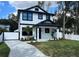 Striking two-story home features black trim, crisp white facade, manicured lawn, and a modern driveway at 4204 N 13Th St, Tampa, FL 33603