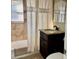 Bathroom with beige tile, tub and dark wood vanity at 4732 W Lawn Ave, Tampa, FL 33611