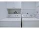 Bright laundry room with washer, dryer, and overhead storage at 5135 Newton S Ave, Gulfport, FL 33707