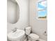 Clean bathroom features a pedestal sink, toilet, and window at 5639 Brooklet Woods Dr, Wesley Chapel, FL 33545