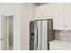 Stainless steel refrigerator in modern kitchen with white cabinetry at 5639 Brooklet Woods Dr, Wesley Chapel, FL 33545