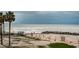 Beachfront view with palm trees and ocean waves at 7100 Sunset Way # 205, St Pete Beach, FL 33706