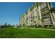 High rise building with green lawn at 7100 Sunset Way # 205, St Pete Beach, FL 33706