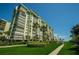 High-rise building with lush landscaping and walkway at 7100 Sunset Way # 205, St Pete Beach, FL 33706