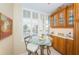 Kitchen nook with glass-top table and chairs, built in cabinets at 7100 Sunset Way # 205, St Pete Beach, FL 33706