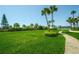 Expansive grassy area with palm trees and walkway at 7100 Sunset Way # 205, St Pete Beach, FL 33706