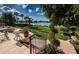 Steps lead to a relaxing patio overlooking a lush lawn and waterfront at 118 Harbor View Ln, Belleair Bluffs, FL 33770