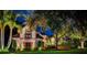 Charming stone home with lush landscaping at night at 118 Harbor View Ln, Belleair Bluffs, FL 33770