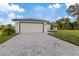 New construction home with a white exterior, gray roof, and a large driveway at 12098 Clarendon Ave, Port Charlotte, FL 33981