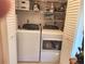 Laundry room with washer, dryer and shelving at 1753 Belleair Forest Dr # F3, Belleair, FL 33756