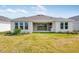 Expansive backyard featuring a covered patio with a built-in kitchen and lush green lawn at 2311 Overfalls Pl, Wesley Chapel, FL 33543