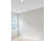 Bright bedroom with white walls, light-colored flooring, a light and a large window at 2311 Overfalls Pl, Wesley Chapel, FL 33543