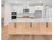 Beautiful kitchen featuring white and wood cabinetry, a large island, stainless steel appliances, and a tile backsplash at 2311 Overfalls Pl, Wesley Chapel, FL 33543