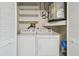 Stackable washer and dryer in a well-lit laundry closet with extra shelving at 2460 Northside Dr # 1407, Clearwater, FL 33761