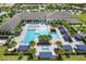 Aerial view of resort-style pool with lounge chairs and cabanas at 4735 Avila Lakes Dr, Wimauma, FL 33598