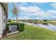 Landscaped backyard with lake view and AC unit at 4735 Avila Lakes Dr, Wimauma, FL 33598