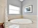 Relaxing bathroom with large corner soaking tub and window at 7145 Peninsular Dr, New Port Richey, FL 34652