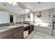 Elegant bathroom featuring double sinks, a soaking tub, and a separate shower at 11411 Alachua Creek Ln, Riverview, FL 33579