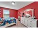 Red and white bedroom with twin-size bed and lots of storage at 11411 Alachua Creek Ln, Riverview, FL 33579