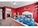 Red bedroom with twin-size bed and adjacent closet at 11411 Alachua Creek Ln, Riverview, FL 33579