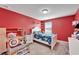 Red bedroom with twin-size bed and plenty of storage at 11411 Alachua Creek Ln, Riverview, FL 33579