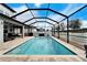 Enclosed pool area with patio, lounge chairs, and grill at 11411 Alachua Creek Ln, Riverview, FL 33579