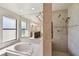 Bright bathroom featuring a soaking tub, glass enclosed shower and a large mirror reflecting the vanity area at 4617 Westford Cir, Tampa, FL 33618