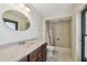 Bathroom with granite countertop vanity, tiled shower-tub combo, and decorative mirror at 4617 Westford Cir, Tampa, FL 33618