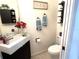 Clean and well-lit half bathroom with a pedestal sink and toilet at 12705 Longcrest Dr, Riverview, FL 33579