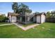 Home's exterior showcasing a screened porch and grassy yard at 4721 Grove Point Dr, Tampa, FL 33624