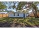 Landscaped backyard with a large grassy area and wooden fence at 609 W Henry Ave, Tampa, FL 33604