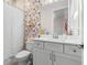 Charming bathroom with floral wallpaper and white vanity at 9028 Ivy Stark Blvd, Wesley Chapel, FL 33545