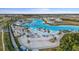 Aerial view of a sparkling lagoon with beach, palm trees, and volleyball court at 9028 Ivy Stark Blvd, Wesley Chapel, FL 33545